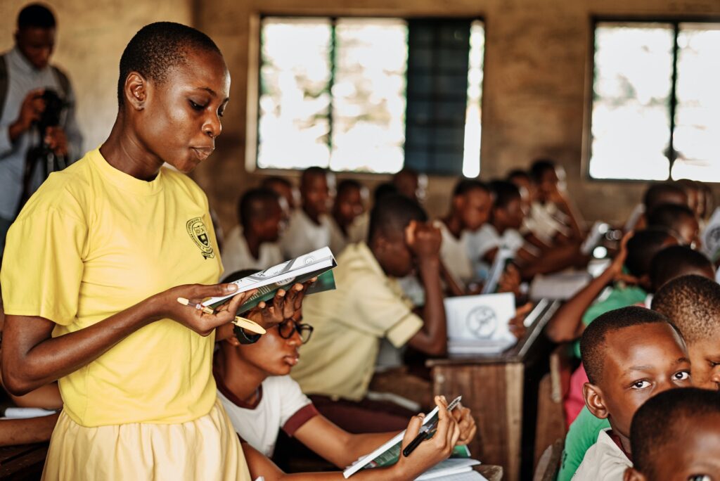 criança africaca lendo livro na escola
